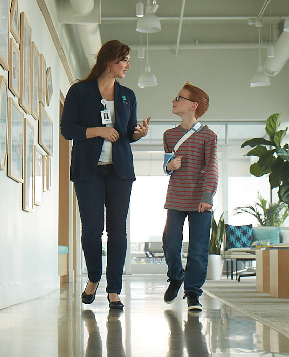 A Spira Care consultant walking and talking with a young patient.