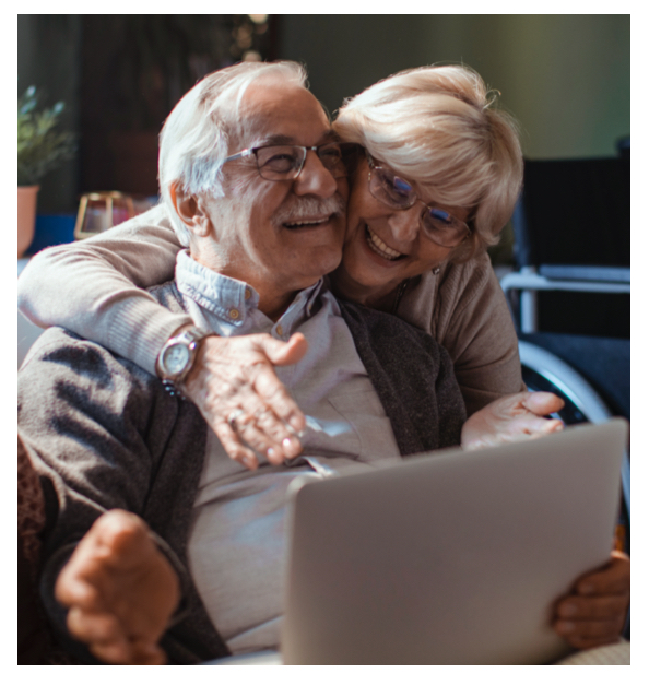 Elderly couple smile while using the computer together